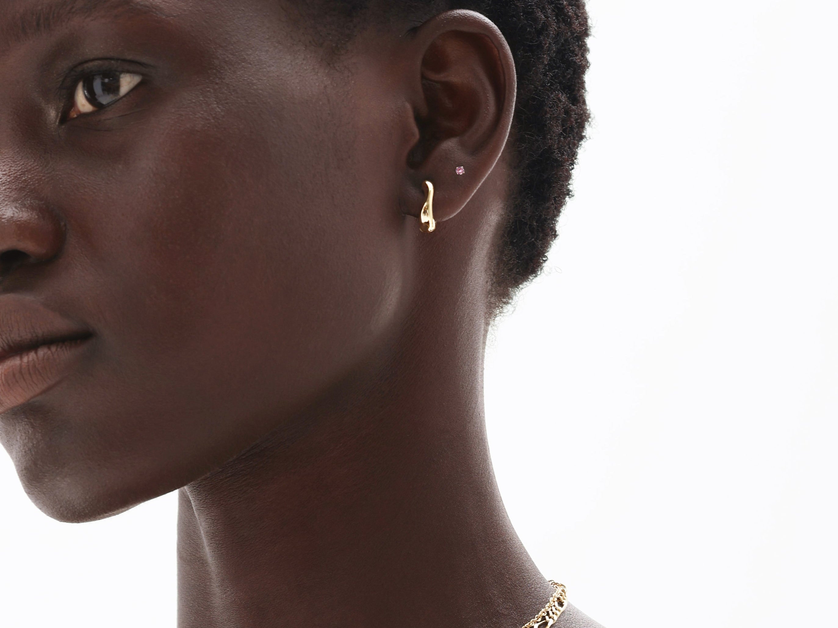 Woman wearing 14K solid gold pink tourmaline earrings and delicate chain necklace showcasing October birthstone jewelry