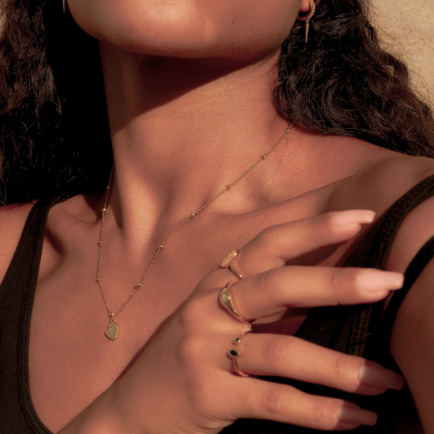 Kosiner jewelry Stacked rings in mixed metals styled with neutral-toned nails