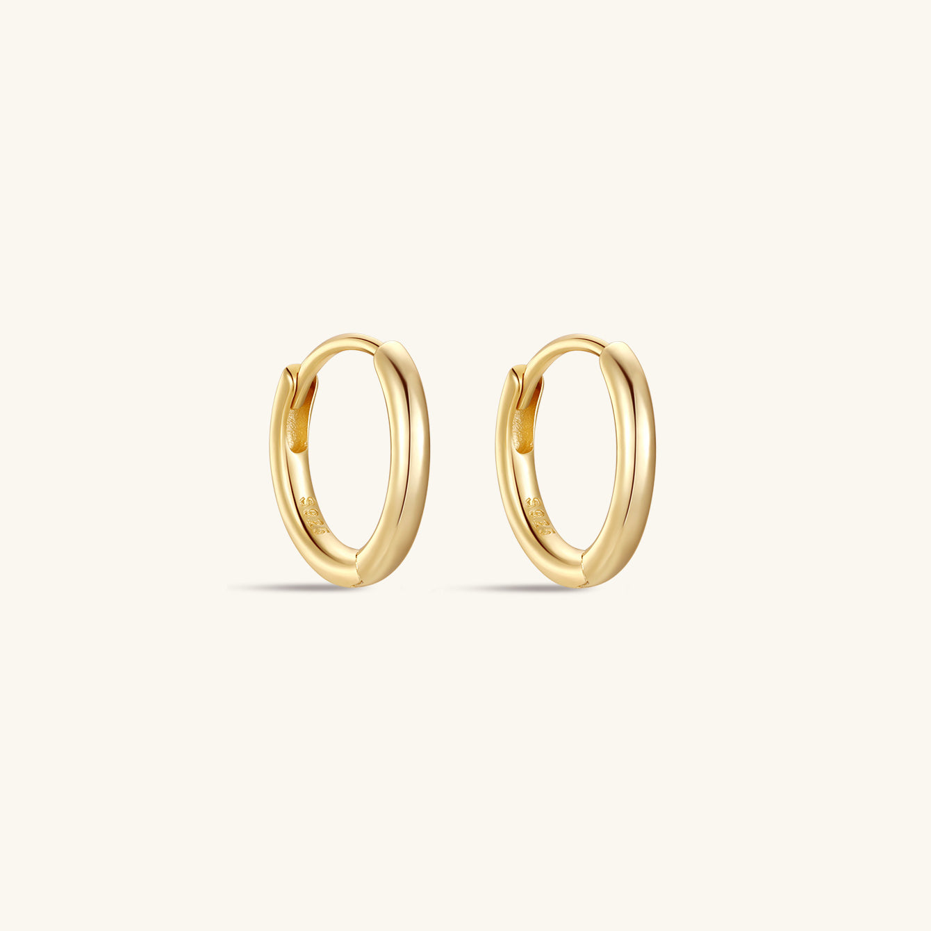 Pair of polished 18K gold-plated 925 sterling silver huggie hoop earrings on white background, classic casual wear.