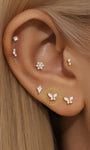 14K solid gold butterfly piercing studs with AAAAA cubic zirconia, styled in an ear stack.