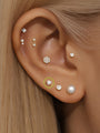 14K solid gold mini stud earring with white opal gemstone, shown in ear stack with diamond and pearl earrings.