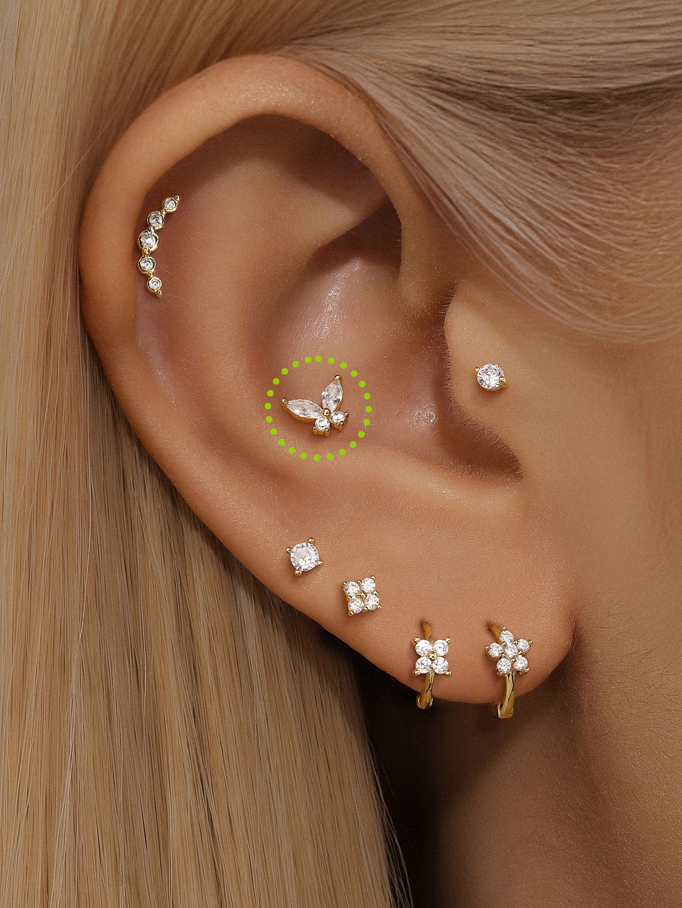 14K solid gold butterfly piercing stud with cubic zirconia, shown on ear cartilage. Internally threaded flatback labret.