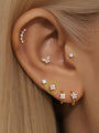 14K solid gold four cubic zirconia flower stud earring on ear, flatback labret design, internally threaded.