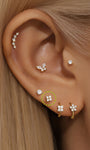 Orecchino a bottone a fiore con quattro zirconi cubici in oro massiccio 14K sull'orecchio, design labret con retro piatto, filettato internamente.