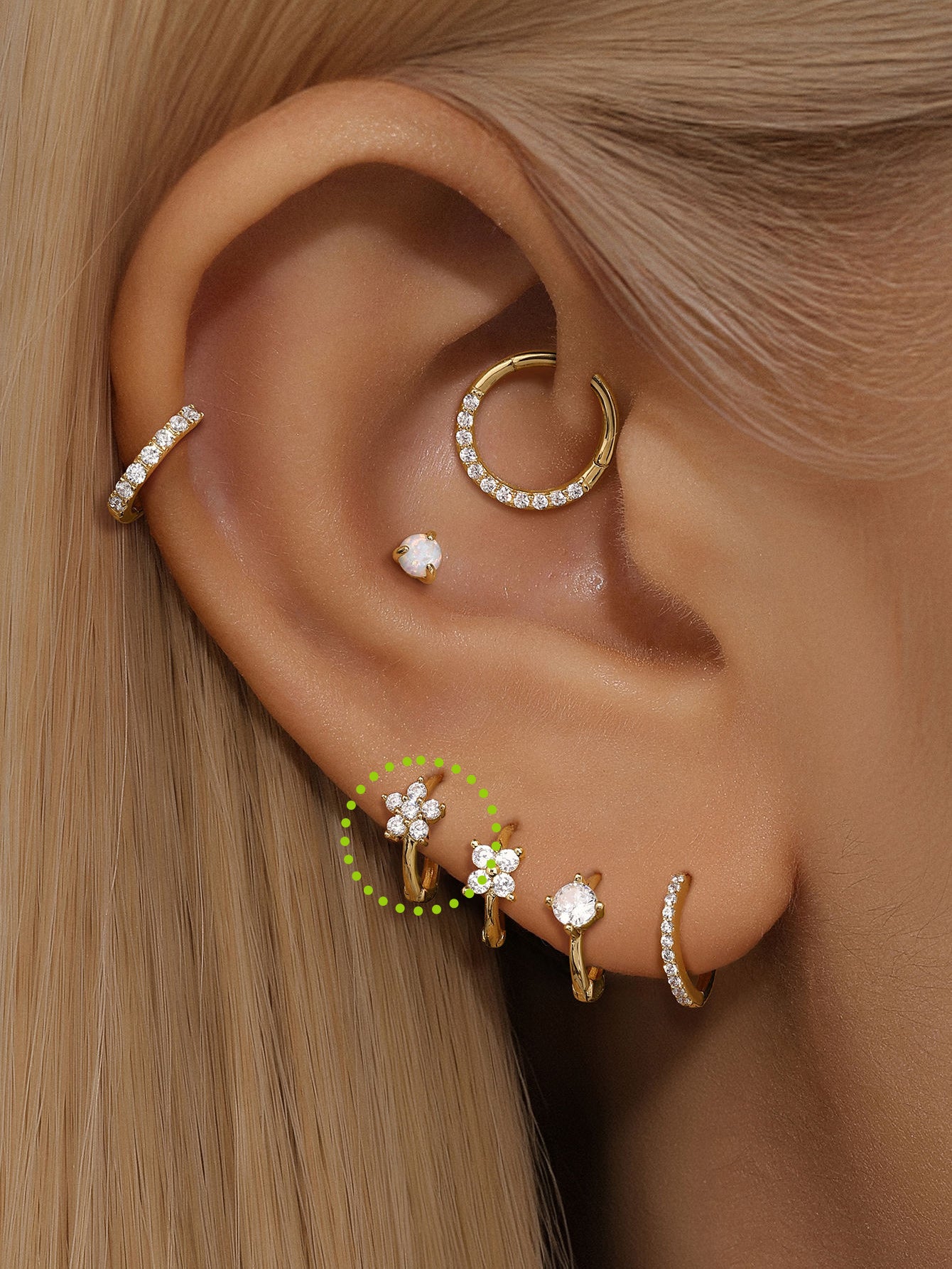 14K solid gold small hoop earrings with flower-shaped cubic zirconia, 6mm inner diameter, shown on ear for scale.
