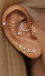 Perno per piercing all'orecchio a quattro fiori in oro massiccio 14K con pietre di zirconia cubica trasparenti, modellato sull'orecchio con piercing multipli.