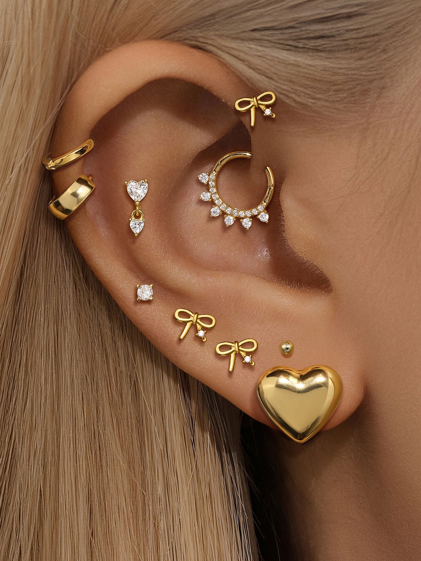 Gold-plated sterling silver bowknot stud earrings with cubic zirconia, part of a curated ear stack display.