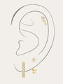 3-piece 18k gold-plated cubic zirconia earring set: hoop, ascending stud, square stud on a woman's ear.