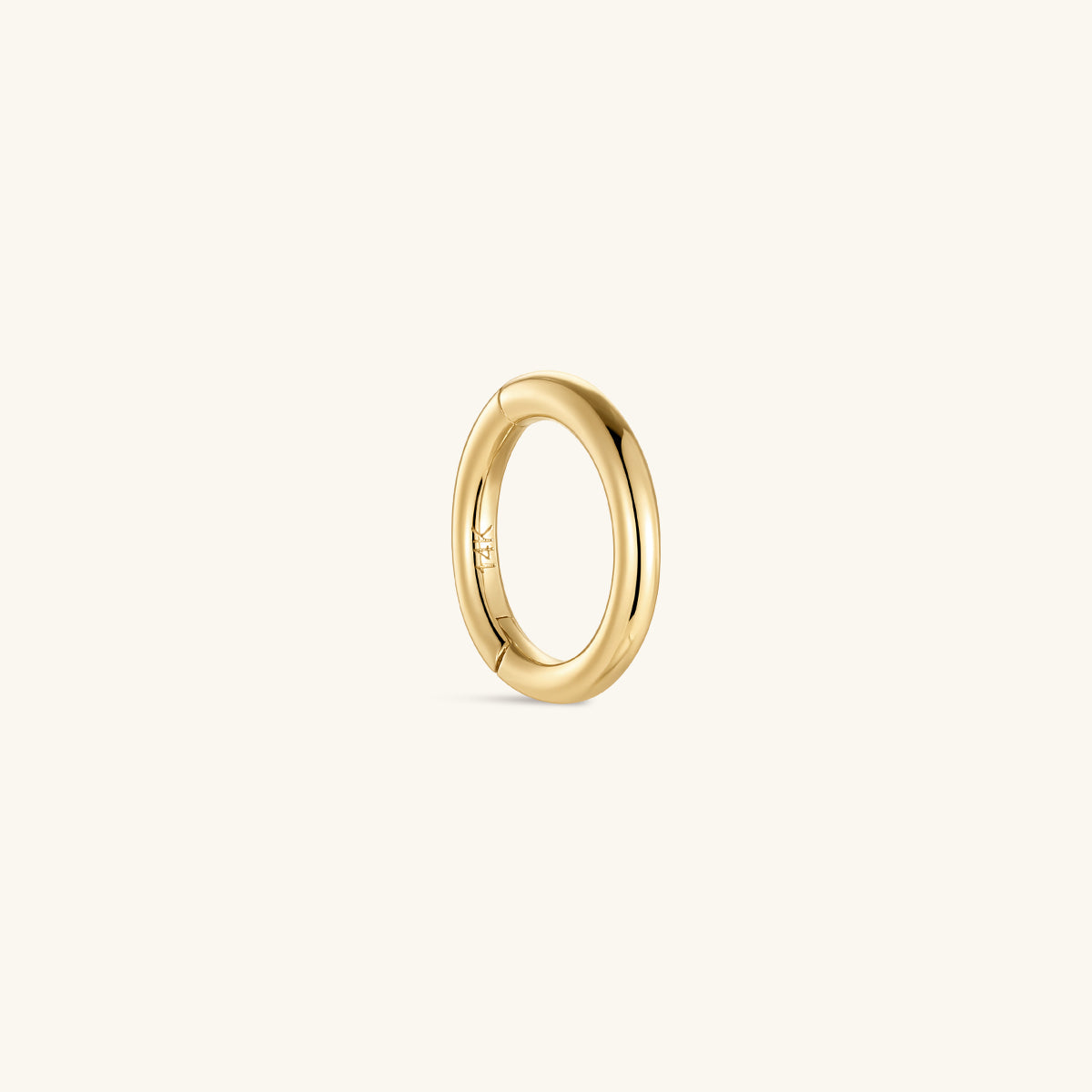 Single KOSINER 14K solid gold minimalist clicker hoop isolated on off-white background, engraved 14K marking on inner band, smooth polished round hinged piercing ring