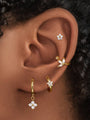 Gold-plated 925 sterling silver ear piercings showcasing flower stud, leaf cuff, and flower dangle hoop with CZ stones.