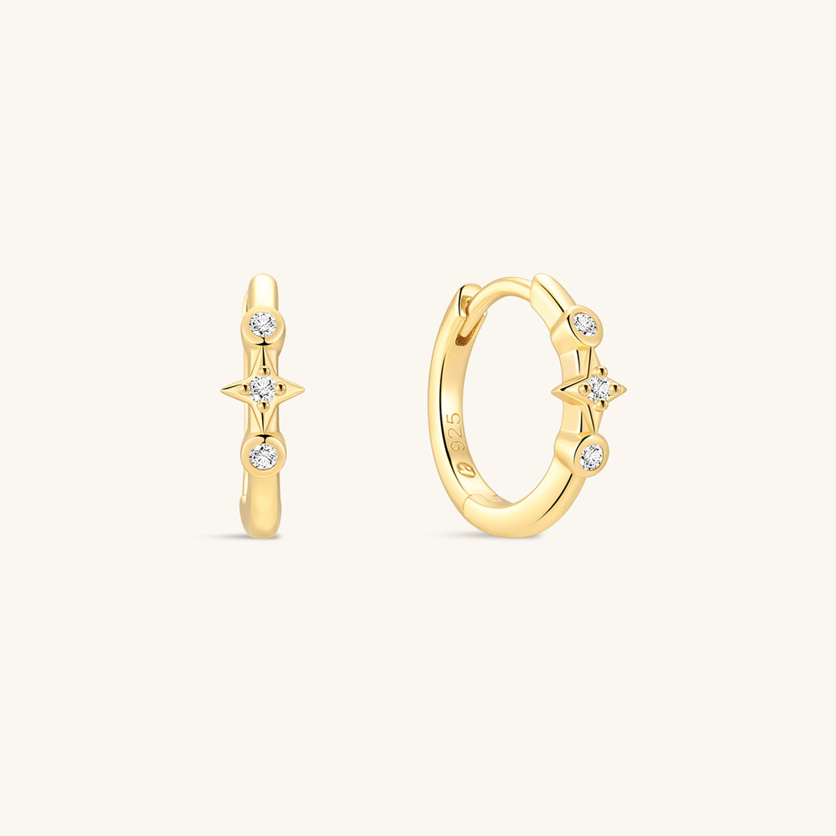 Pair of KOSINER Starlight minimalist hoop earrings front view, polished 925 sterling silver base plated in 18K gold vermeil, hinged clicker hoop detailed with central four-point star set with clear cubic zirconia, flanked by two round bezel-set CZ accents, inner band stamped 925 sterling silver marking