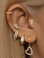 Gold 925 sterling silver butterfly ear piercing stud with cubic zirconia, styled with other gold earrings on an ear.