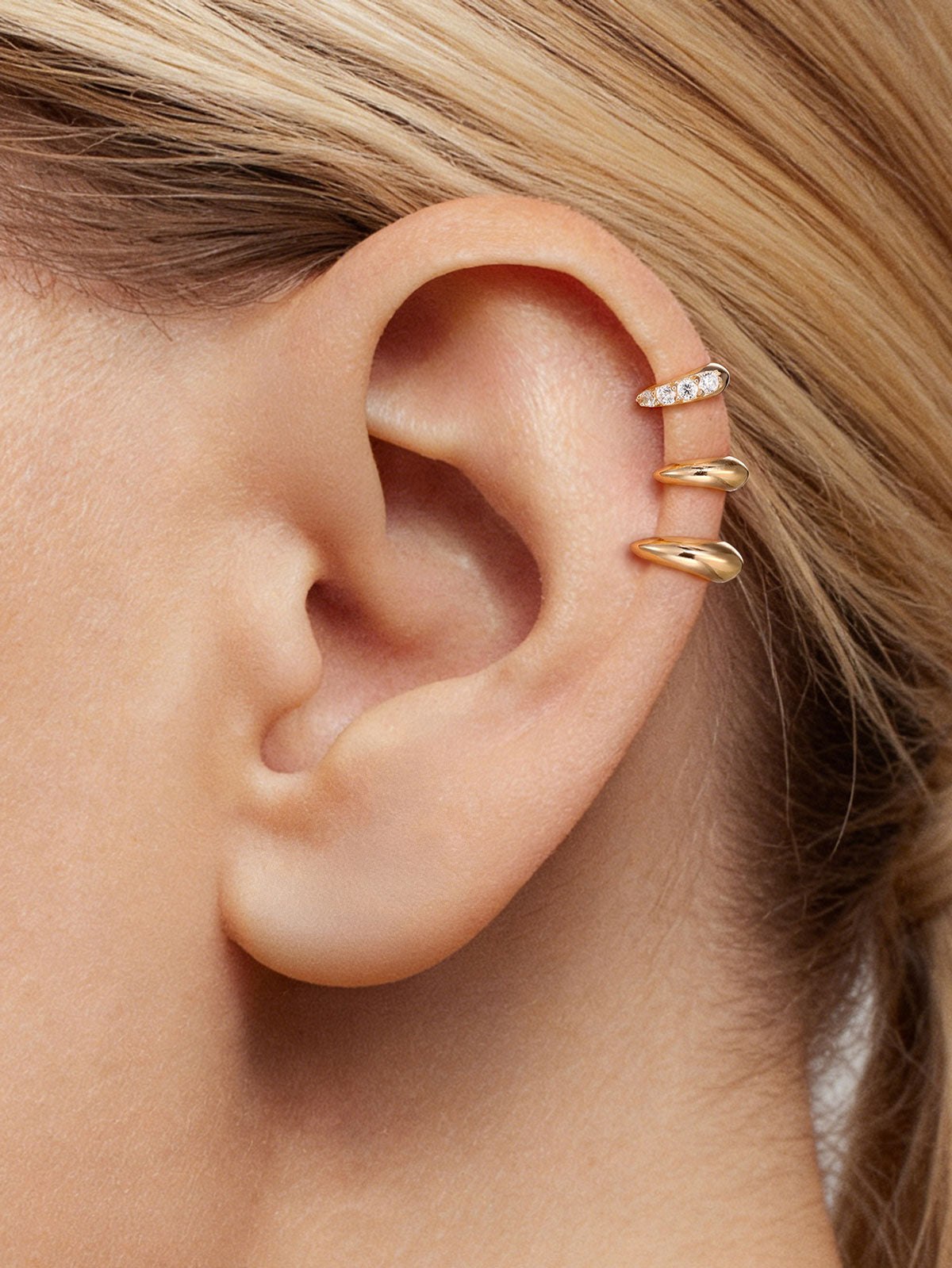 Close-up ear stacking photo showing KOSINER 14K solid gold C-shape flat back stud worn on helix piercing, paired with pave crystal matching style for delicate layered cartilage ear styling