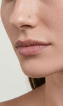 Close-up facial shot showcasing KOSINER twist hook nose stud worn on nostril piercing, subtle minimalist everyday nose jewelry styling