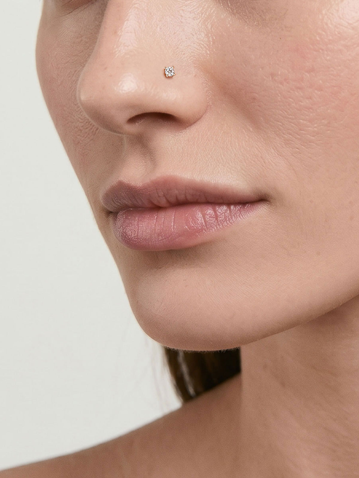 Close-up facial shot showcasing KOSINER twist hook nose stud worn on nostril piercing, subtle minimalist everyday nose jewelry styling