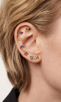 Patriotic USA themed ear stacking layout with KOSINER Independence Day patriotic USA letter flat back stud on earlobe, matched with heart, bow, crown and star flag-inspired cartilage piercings, festive multi-piercing styling for Fourth of July celebration