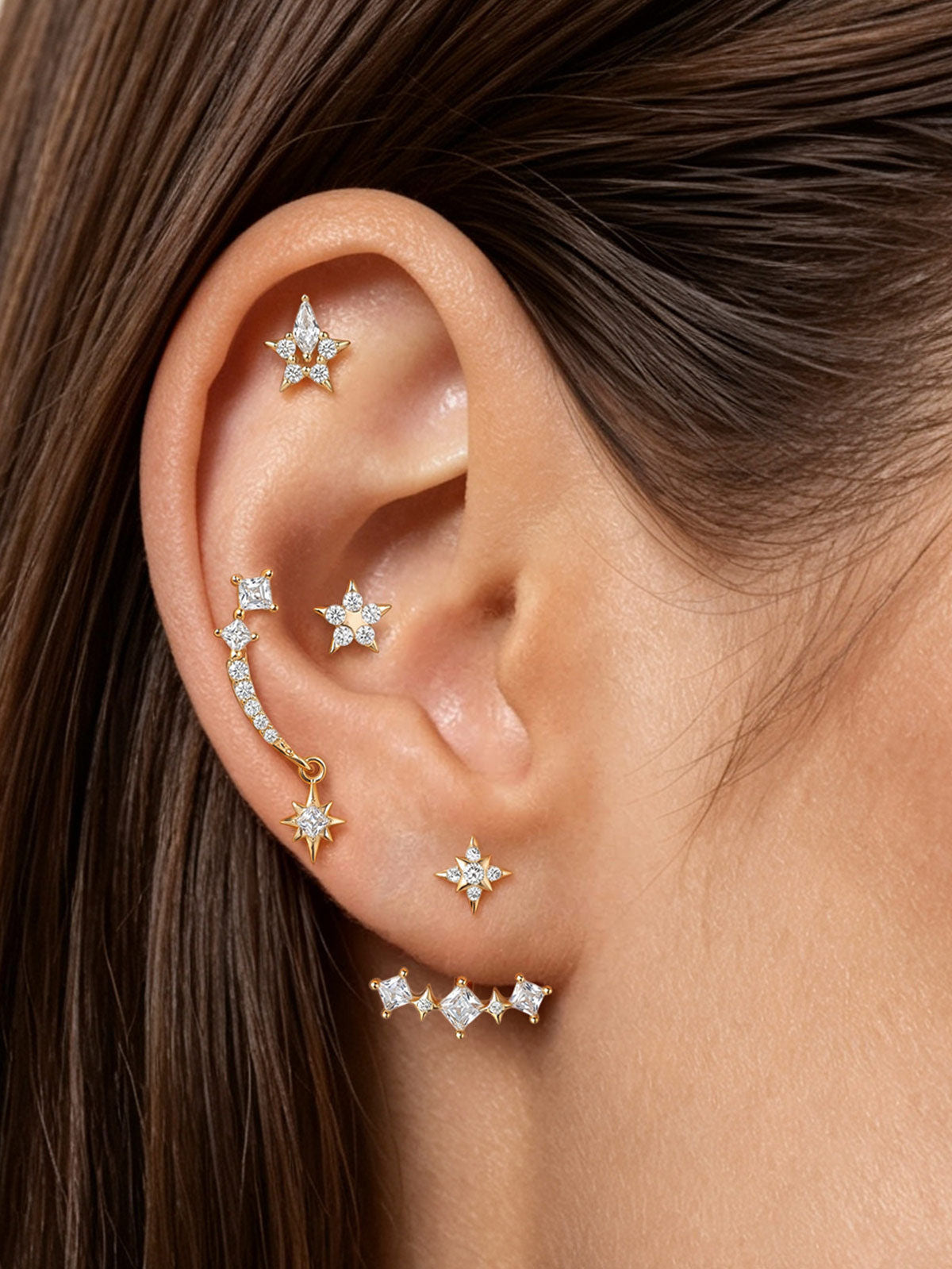 Angled view of KOSINER Rising Star gold-plated Hollow Star stud on a cream background showing its round flat back