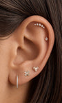 Refined curated ear stacking layout with KOSINER hand hammered clover flat back stud on earlobe, matched with heart piercing stud, star stud, linear CZ bar and pavé hoop, elegant multi-piercing styling