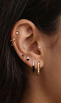Refined layered full ear stacking look with KOSINER Puzzle dual-tone black enamel cz sterling silver hoop earring, paired tiny cz studs, geometric triangle two-tone studs, minimalist gold hoops, sleek contemporary everyday ear styling