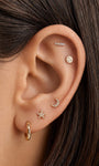 Curated layered ear styling featuring KOSINER hand hammered textured star flat back stud on earlobe, paired with hammered moon stud, disc stud, bar stud and textured hoop, cohesive hammered-metal minimalist multi-piercing layout