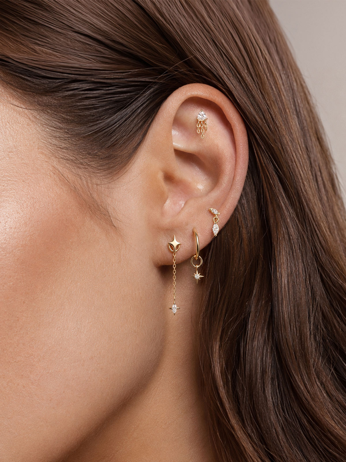 Brunette model curated ear stack with 14K gold double marquise dangle flat back stud, multi‑piercing lifestyle close‑up shot
