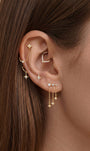 Elegant curated multi-piercing ear stack featuring KOSINER Starlight delicate four-point star flat back stud fitted on upper helix, styled with matching star motif accessories, marquise stone daith hoop, dual inter-piercing chain, teardrop outline stud and dangling star drop earrings, sophisticated layered ear styling design