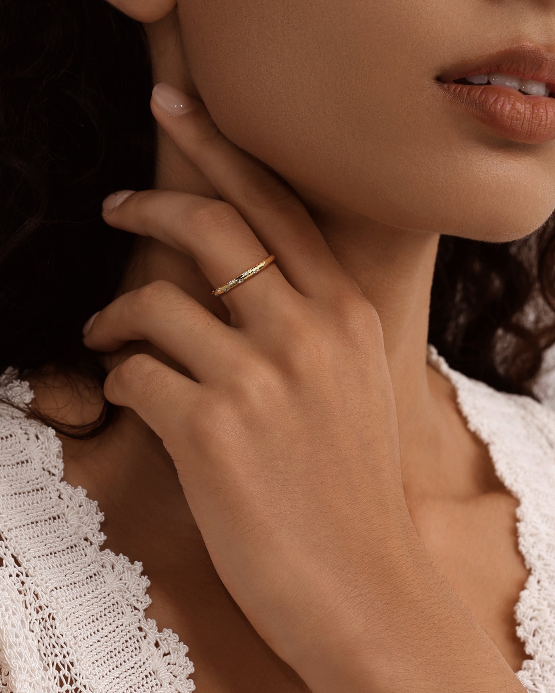 Close-up lifestyle shot of KOSINER hammered textured thin ring worn on finger, warm gold finish delicate band design, elegant everyday minimalist stackable ring styling