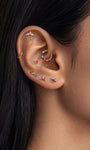 Layered helix ear stacking look with KOSINER rainbow light collection, crown chain pendant flat back stud matched with assorted rainbow cartilage piercings