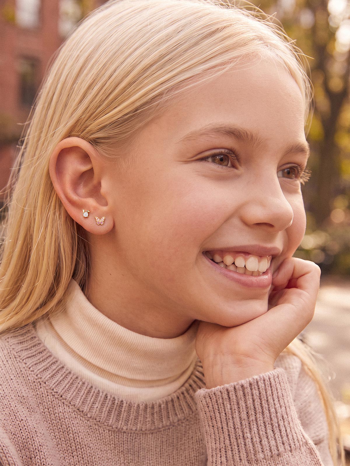 Model wearing the Little Wonder 14K gold butterfly flat back stud in an ear stack