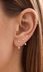 Women ear styling look wearing KOSINER 14K gold pear curved barbell cartilage hoop earring, multiple ear piercings stack delicate gold piercing jewelry daily wear
