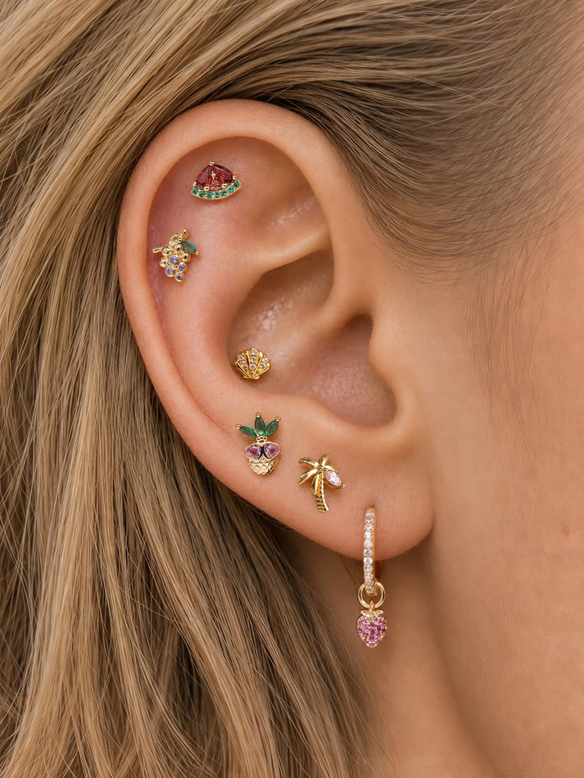 Full layered ear stack of KOSINER Orchard fruit collection, pineapple silver flat stud matched with watermelon, grape, seashell, palm tree cartilage piercing earrings