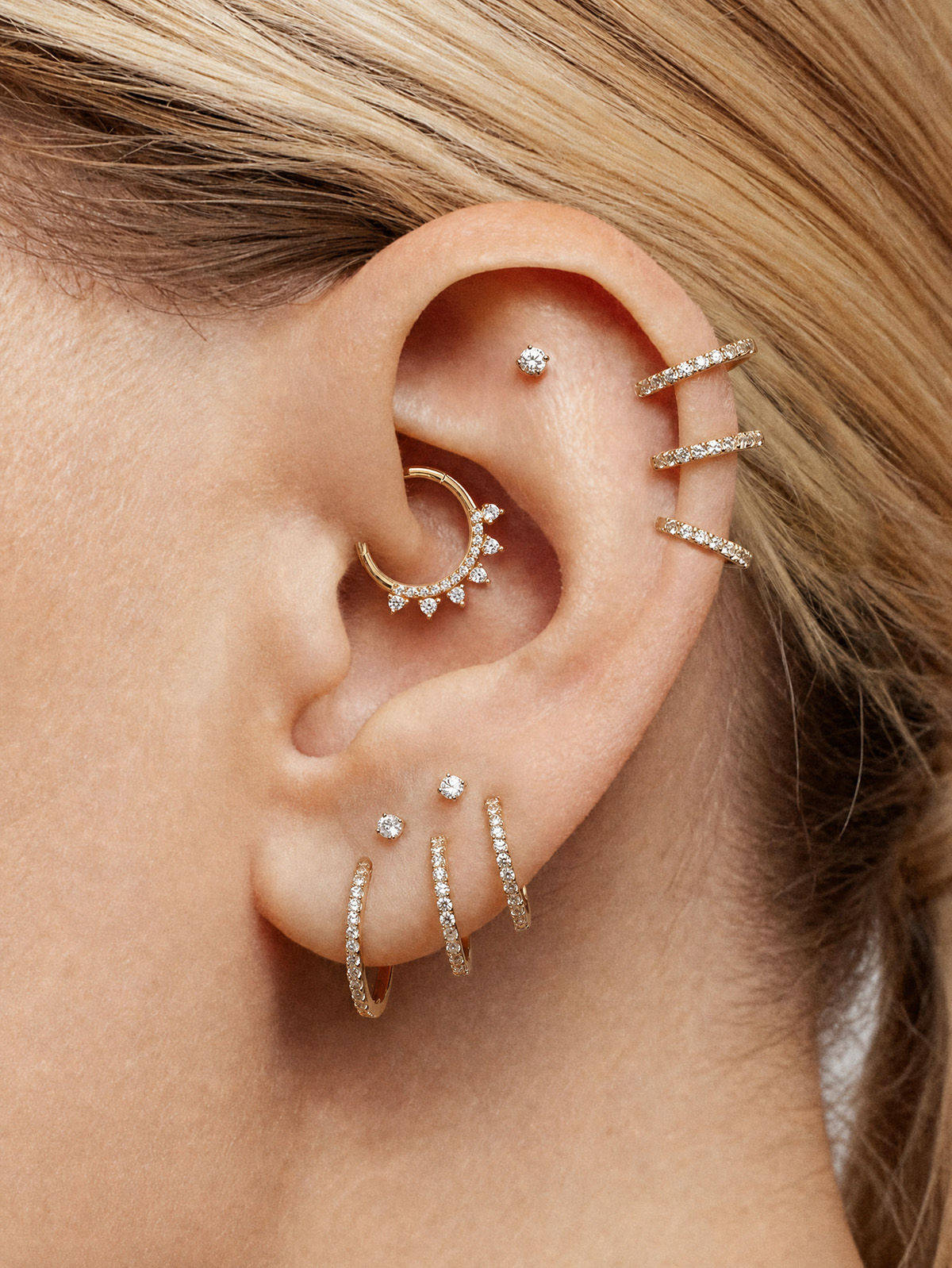 14K gold ear curation: sunburst daith hoop, crystal cuff, floral, heart, ball studs w/ AAAAA cubic zirconia.