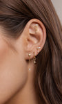 Model curated multi piercing ear styling, 14k gold long chain marquise star detachable dangle charm on gold hoop earring, layered celestial ear jewellery