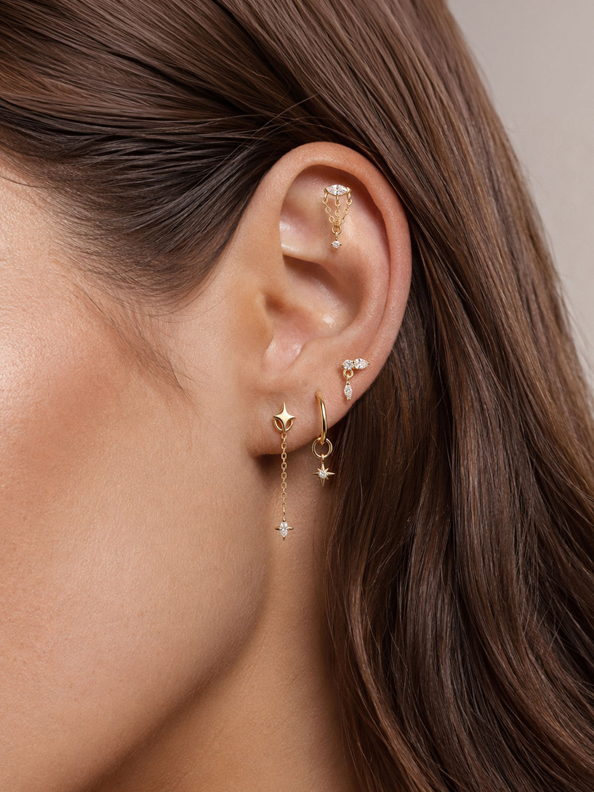 Model curated multi piercing ear styling, 14k gold long chain marquise star detachable dangle charm on gold hoop earring, layered celestial ear jewellery