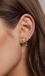 Model wearing 14k gold triangle tassel cz flat back stud on upper helix, curated stack ear piercing look, dangle chain cartilage jewelry