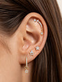 KOSINER Rising Star gold-plated star dangle hoop on a cream background showing clear stones and a hinged closure