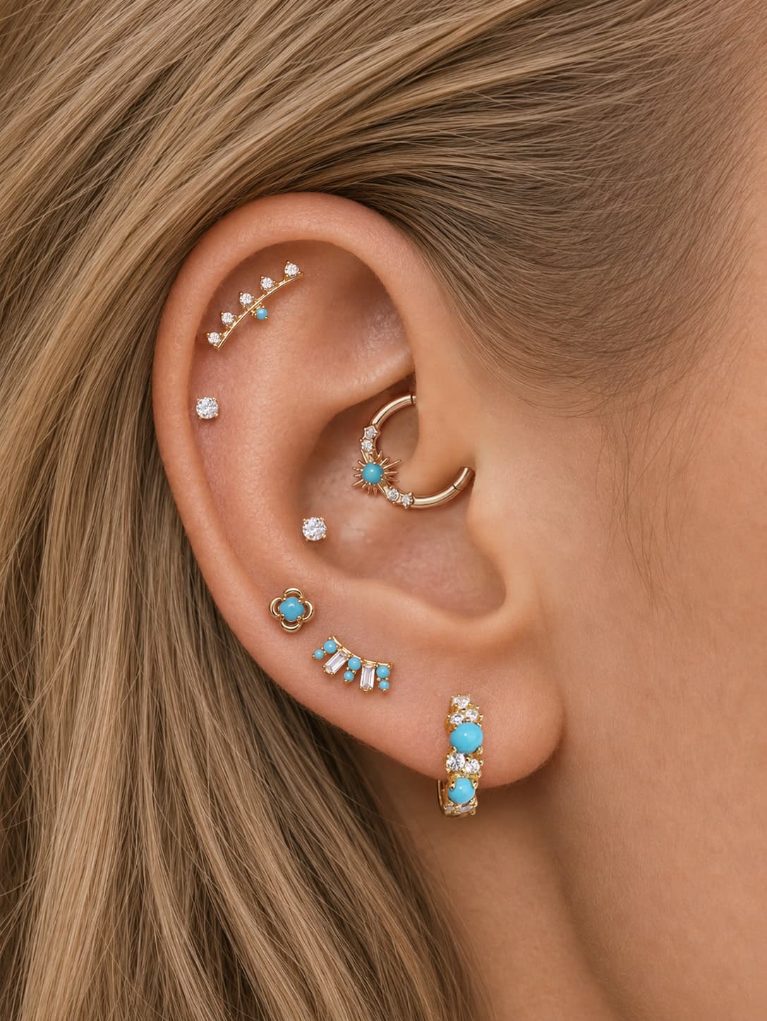 Vintage-style curated ear layout featuring KOSINER Étoile clover turquoise flat back stud on earlobe, matched with turquoise-accent hoops and crystal stud variants, harmonious boho refined multi-piercing styling