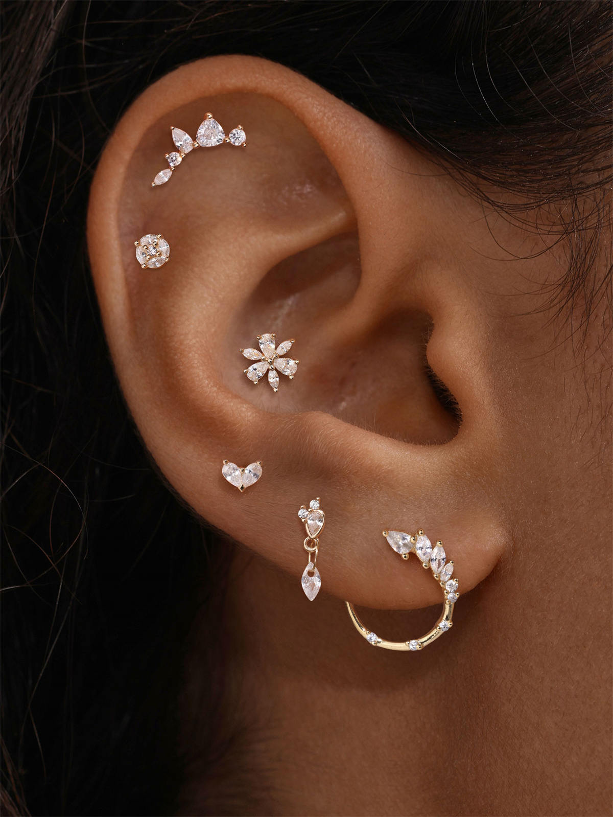 KOSINER ear stacking look with assorted KOSINER 14K solid gold heart-shaped cartilage piercing studs, multi-position helix lobe layered ear jewelry styling