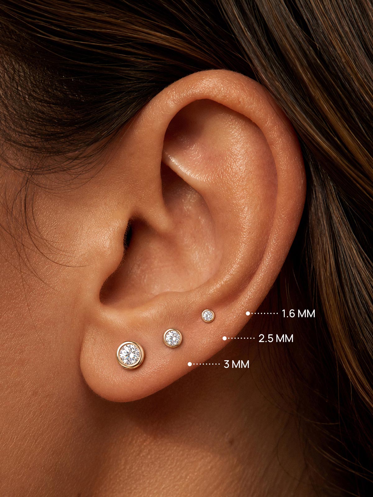 KOSINER round bezel lab-grown diamond flat back studs in 1.6mm, 2.5mm and 3mm sizes on ear