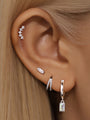 925 sterling silver ear stack with cubic zirconia studs, pavé hoop, and drop earring with square zircon, shown on ear.