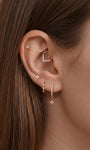 Elegant curated multi-piercing ear stack featuring KOSINER Starlight octagonal star flat back stud worn on upper helix, styled with matching small star stud, marquise stone daith hoop, dual chain connecting lobe piercing, teardrop outline stud and drop star hoop, sophisticated layered ear styling design