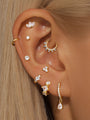 Gold-plated sterling silver ear piercings with cubic zirconia, showing various stud and hoop styles.