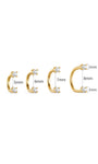 Four sizes of KOSINER 14K solid gold curved barbell piercings with two prong-set round cubic zirconia stones, minimalist open C shape cartilage studs arranged on warm beige background