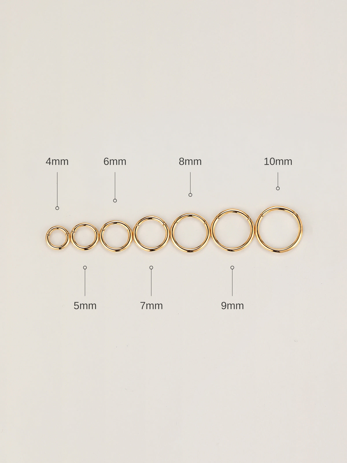 Horizontal size arrangement of KOSINER 14K solid gold minimalist clicker hoops, clearly marked 4mm to 10mm outer diameters for size selection reference on neutral white backdrop