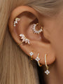 Gold 925 Sterling Silver butterfly ear piercing stud with cubic zirconia, styled with other earrings.