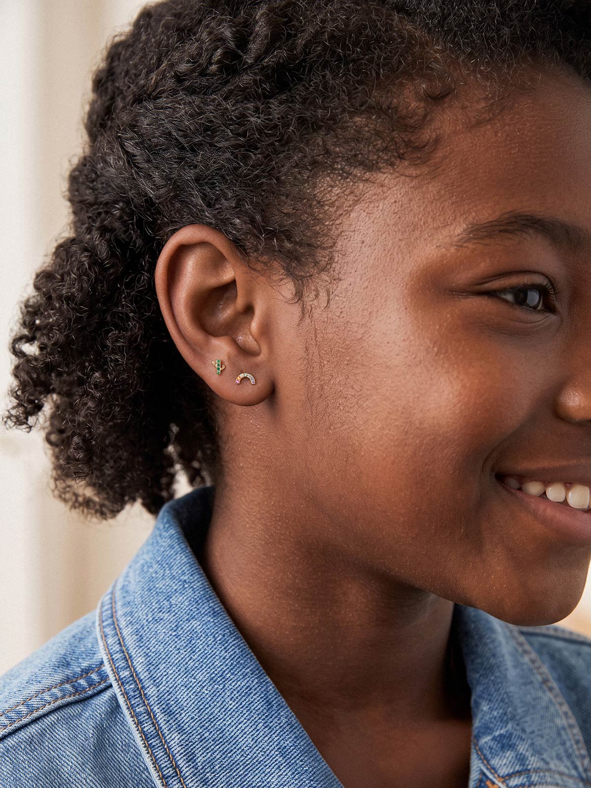 Model wearing a 14K gold rainbow stud with coordinating flat back earrings