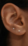 Close-up ear styling with KOSINER Étoile dainty triangular CZ flat back stud paired with square solitaire stud and gold clicker hoop, subtle luxe cartilage piercing combination for daily wear