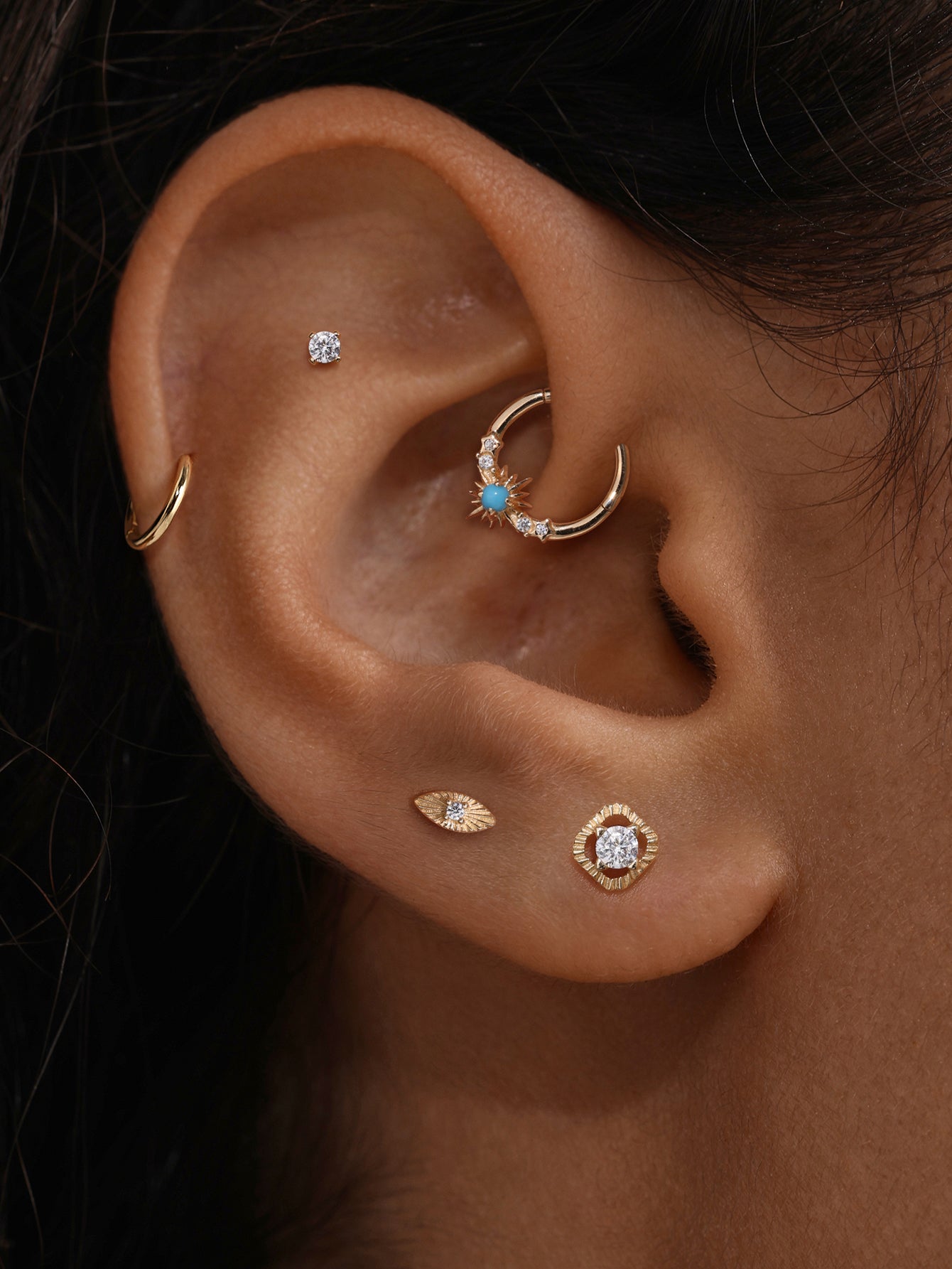 Close-up ear stack display with KOSINER Étoile radiant marquise CZ flat back stud paired with hollow square piercing stud and turquoise detail clicker hoop, delicate vintage-inspired cartilage piercing combination
