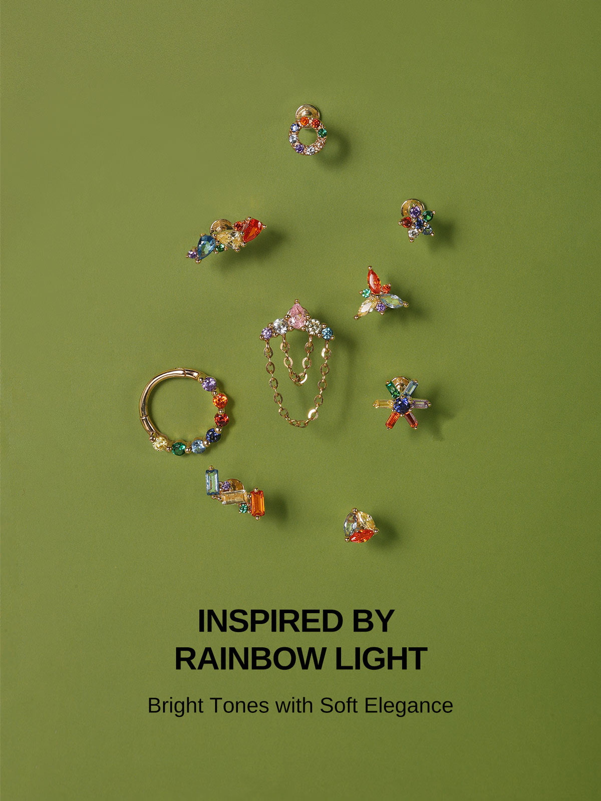 KOSINER Inspired by Rainbow Light full colorful gem piercing collection on sage green background, assorted baguette, pear, round cut 14K gold studs and clicker hoops