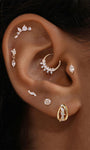 Close-up of ear stacked with dainty KOSINER dual-shape cz drop flat back studs and hoops, elegant multi-ear piercing aesthetic